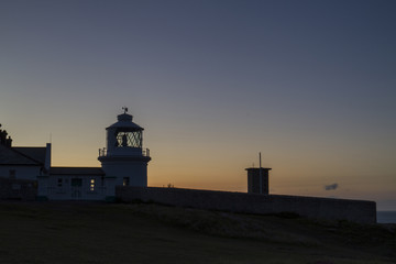 lighthouse silhouette at dawn sunrise