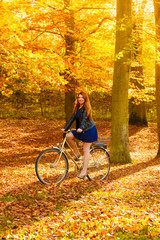 Obraz na płótnie Canvas Beauty girl relaxing in autumn park with bicycle, outdoor