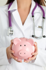 Female Doctor Holding Piggy Bank