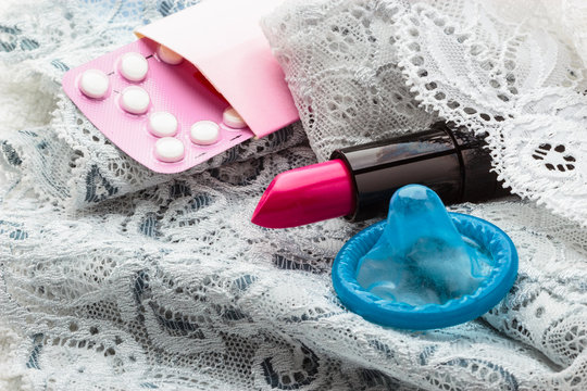 Pills condom and lipstick on lace lingerie