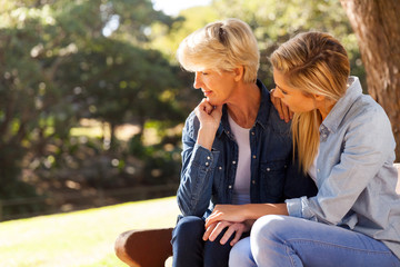 young daughter comforting senior mother