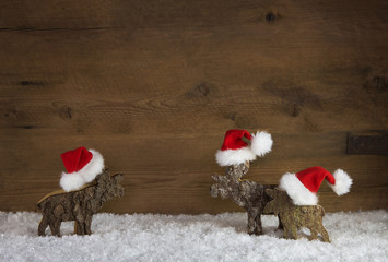 Weihnachtlicher Holz Hintergrund mit Elche in rot und weiß