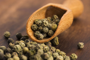Green Peppercorns on wooden background