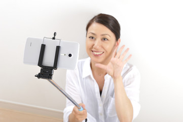 自撮り棒（セルフィー）で自分を撮影している日本人女性