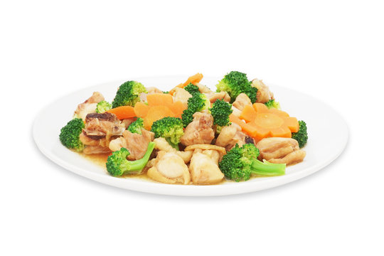 stir fried chicken with broccoli and carrot on plate isolated white background