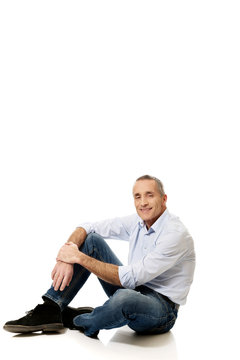 Mature Man Sitting On The Floor