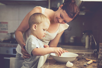 Mother with child cooking together - obrazy, fototapety, plakaty