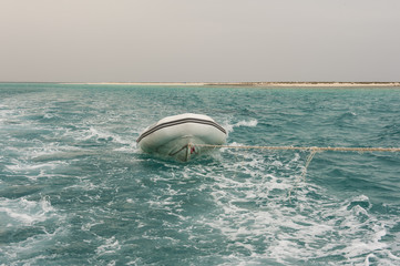 Fototapeta na wymiar Small boat being towed on a tropical sea