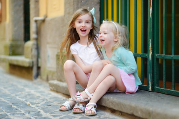 Two adorable little sisters laughing and hugging © MNStudio