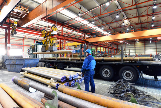 Industriehalle, Arbeiter bedient Kran - Verladung von Stahl