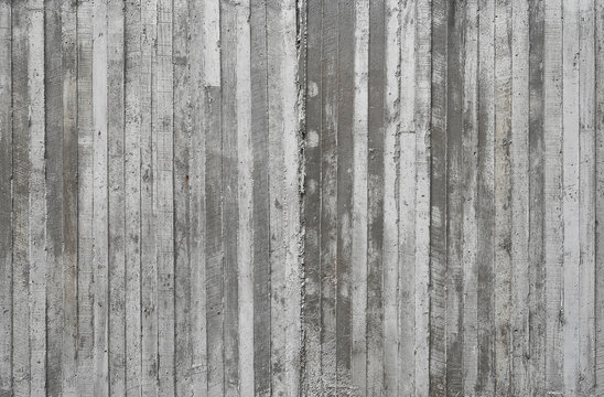 texture of wooden formwork stamped on a raw concrete wall as bac