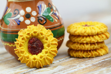 Cookies with jam on rustic wooden surface
