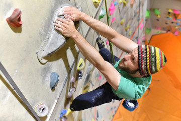 Mann kletter an Felshand in einer Kletterhalle // climbing indoor