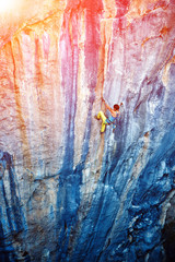 Fototapeta na wymiar Rock climber climbing up a cliff