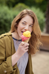 attraktive junge frau im park isst ein eis