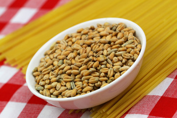 Wheat in bowl on uncooked spaghetti
