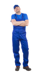 Man in blue overalls with hands crossed.