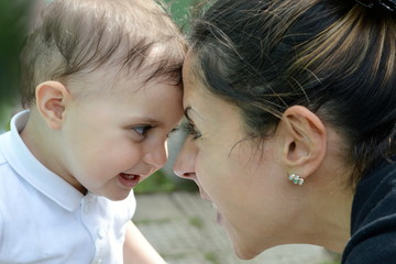 mother kissing baby happy outdoor