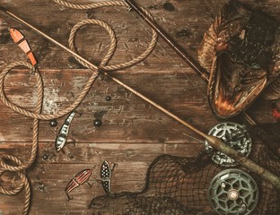 Fishing tools and pike's head on a wooden table