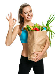 Happy smiling athletic woman showing okay gesture with grocery bag