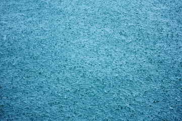 Fototapeta na wymiar Falling raindrops on a tropical turquoise sea water surface