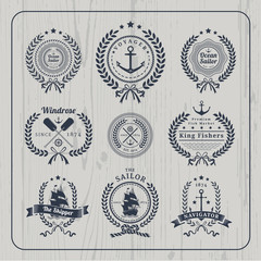 Vintage nautical wreath labels set on light wood background
