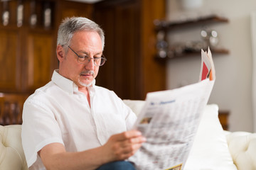 Mature man reading a newspaper