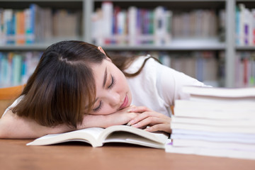 Beautiful asian femle student take nap in library during studyin