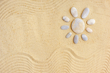 Fototapeta na wymiar Stones arranged like a sun on the beach