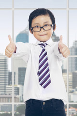 Boy with thumbs up in office