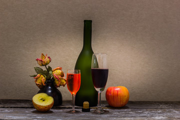 Still life with wine bottle, apple  dry little flower.