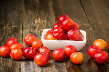 Fresh plum (Julee) on wooden background, healthy fruit