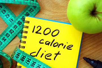 Notepad with 1200 calorie diet, apple and measure tape