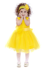 Beautiful curly,dark-haired little girl in a fashionable yellow 