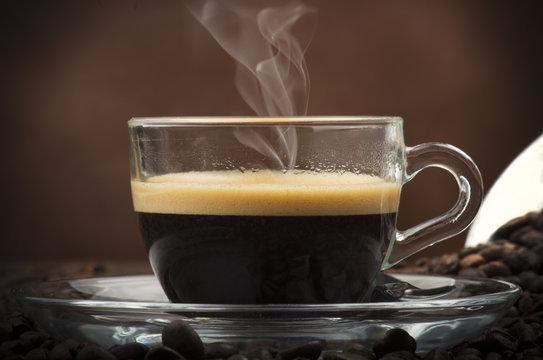 Cup of coffee on the table with seeds