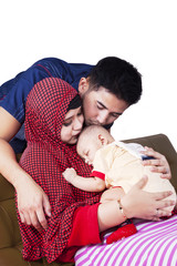 Muslim parents kiss their baby
