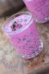Closeup of a glass of cold beetroot soup.