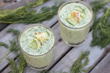 Closeup of glasses of cold cucumber and dill soup.