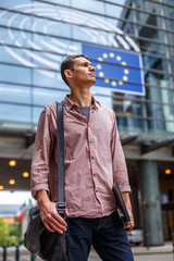 Man in jeans and red shirt on the city street.