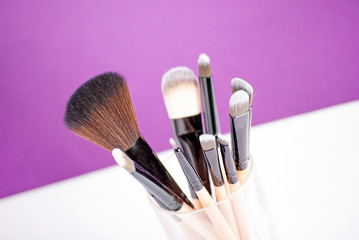 Makeup brushes close up on purple background
