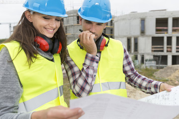 Engineers on building site cheking plans