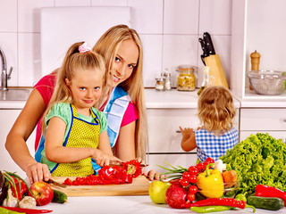 Mother and daughter cooking at kitchen.
