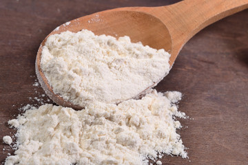 Fototapeta na wymiar White flour in a wooden spoon