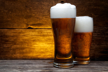 two glasses of beer over vintage wood 