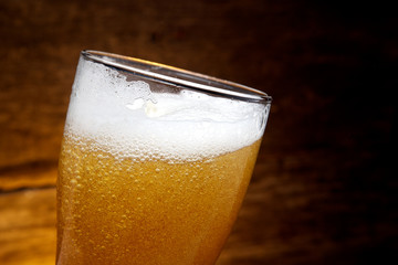 Beer into glass on a old wood