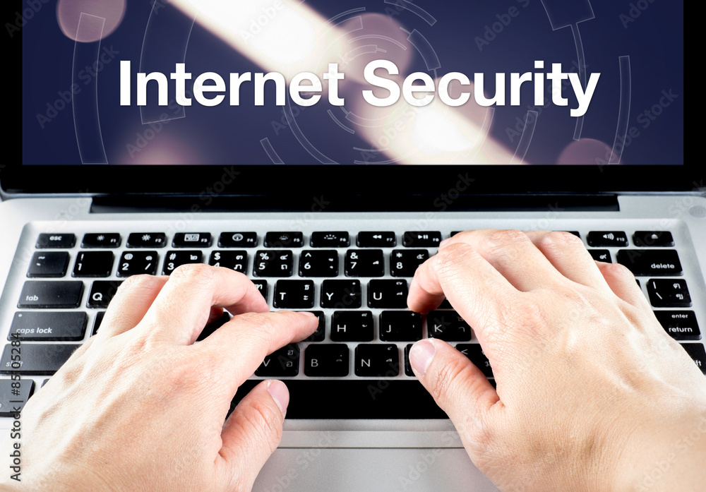 Aufkleber hand type on laptop with internet security on screen with blur b