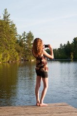 teen girl using her phone to take a photograph