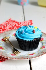 Delicious blue cupcake on a vintage background