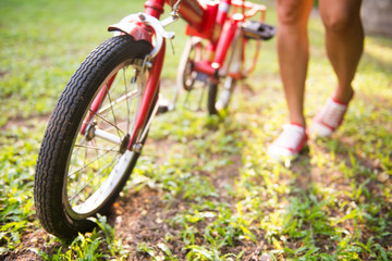 Fototapeta premium girl is holding bicycles in park
