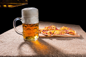 Mug of Beer and Slices of Pizza on Cutting Board